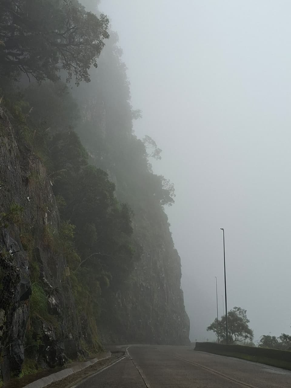 O paredão de pedra some na névoa